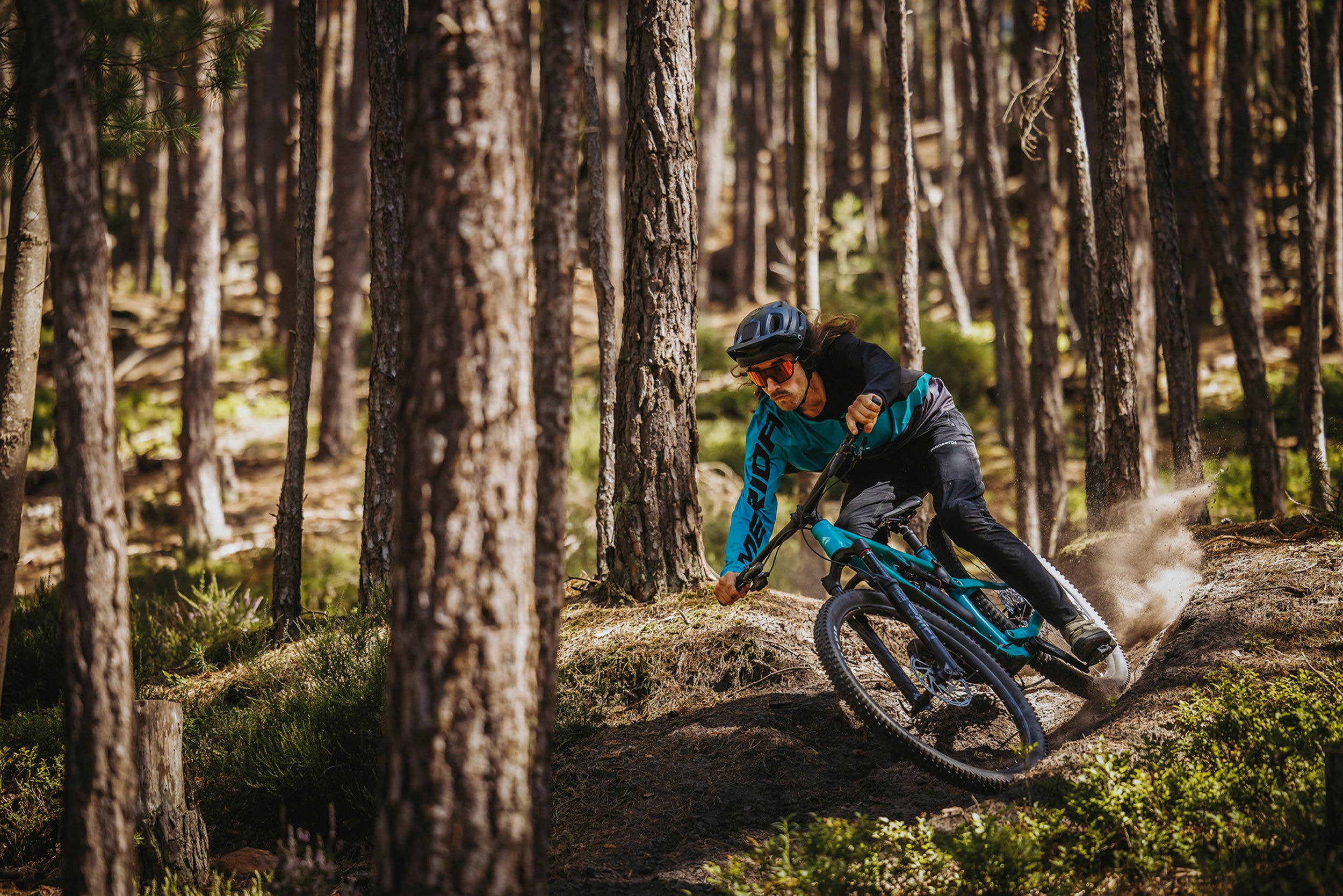 Mountainbiker op een Merida ONE-TWENTY full suspension in een bocht tussen de dennen