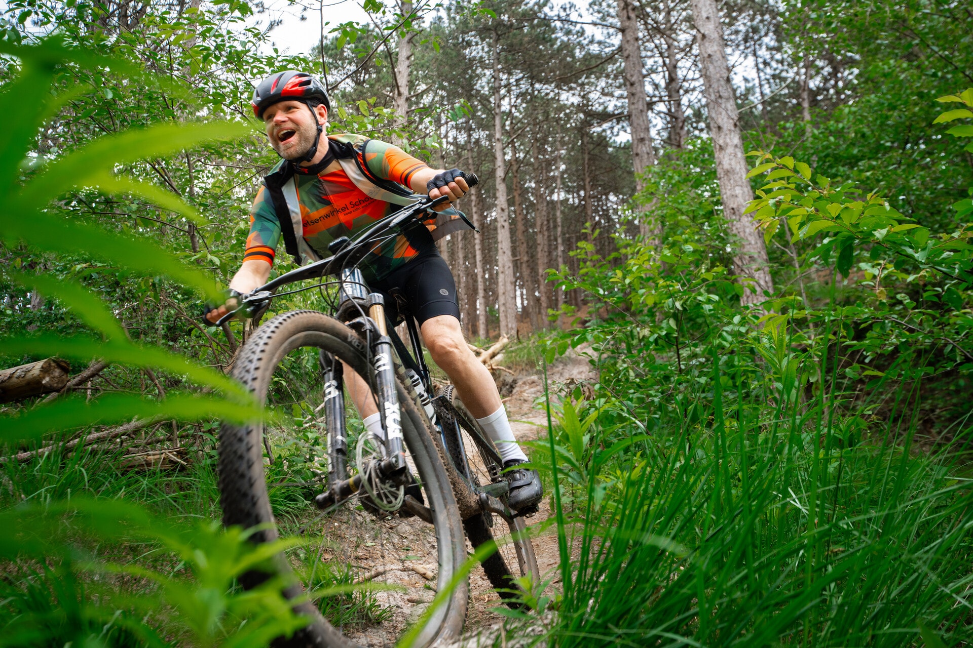 Mountainbiker op MTB Route Schoorl tussen het groen van het duingebied